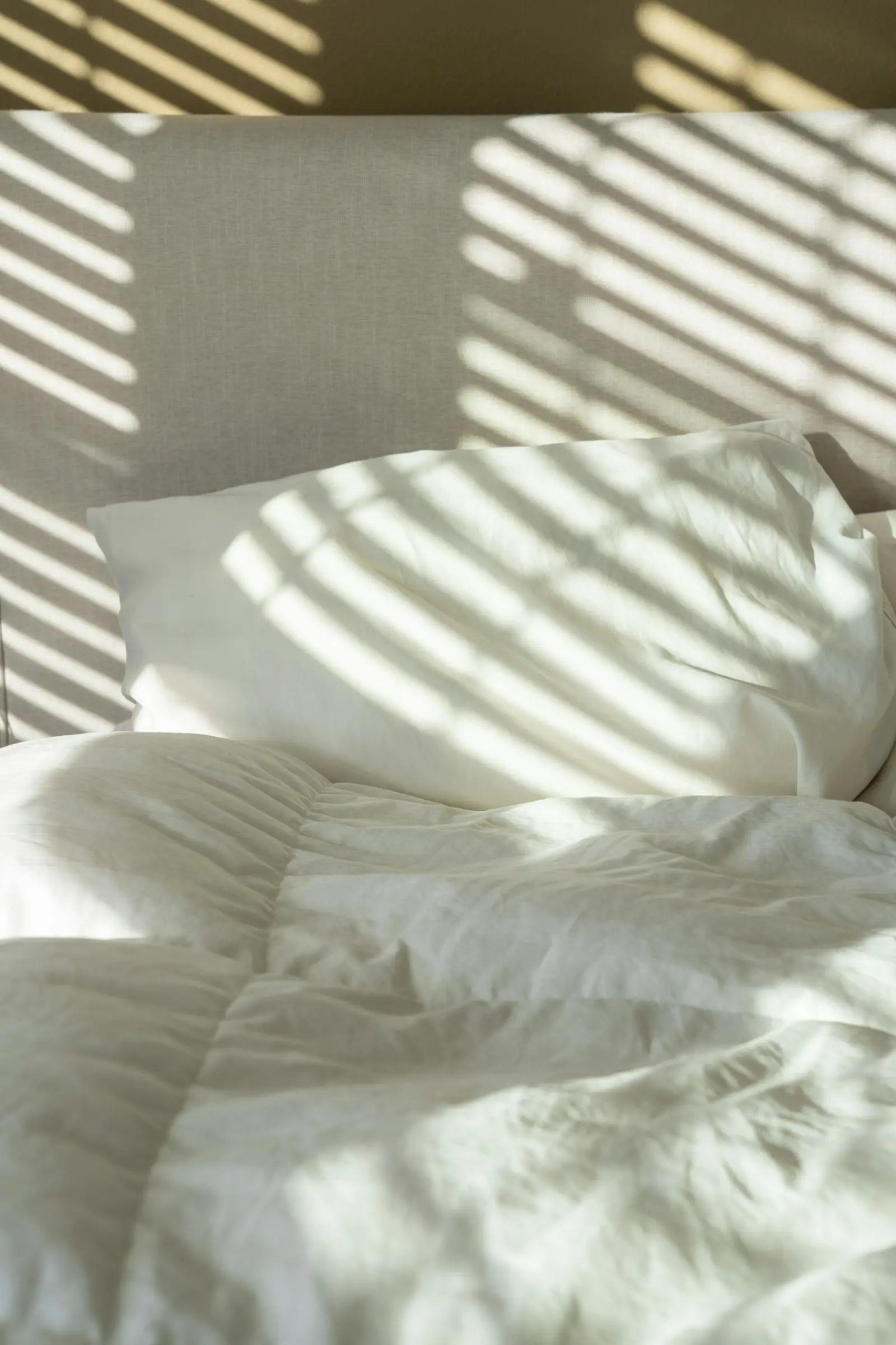 White duvet and pillow in morning light