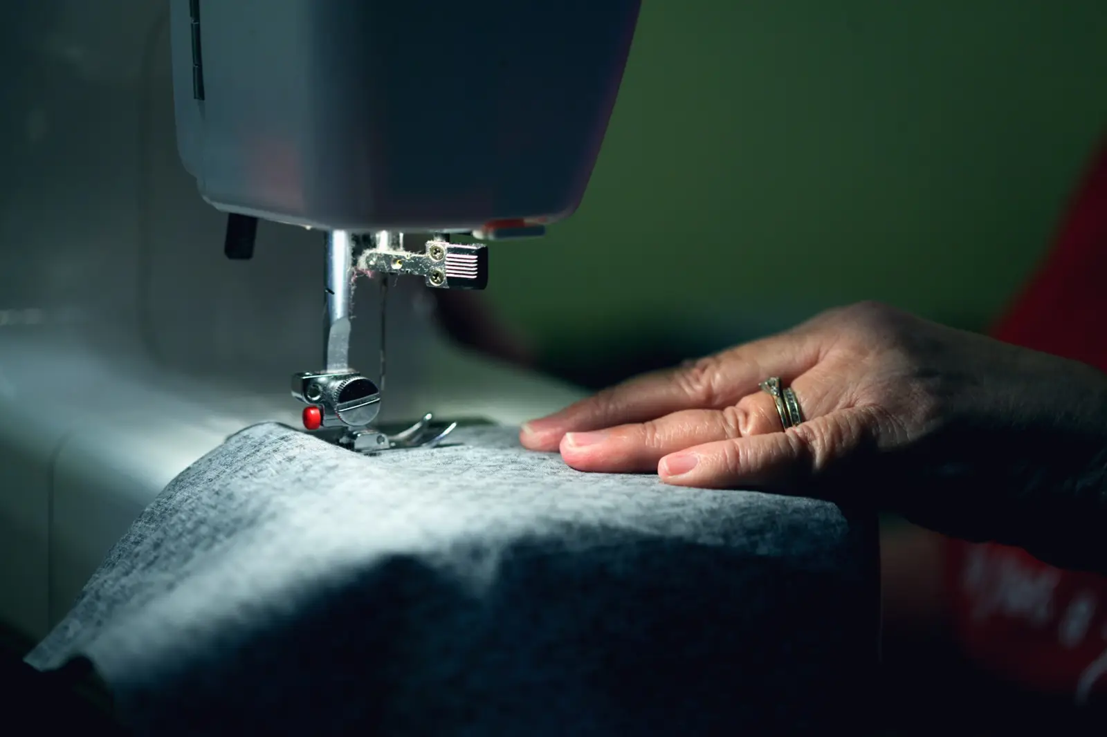 Hands guiding fabric through a sewing machine while making a sample
